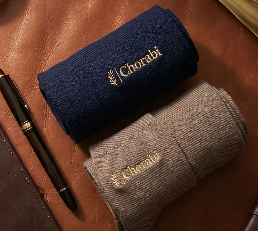 Navy and beige socks with gold Chorabi embroidery, a fountain pen and a leather wallet